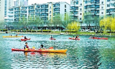 图为游客们正在海河故道公园划船
